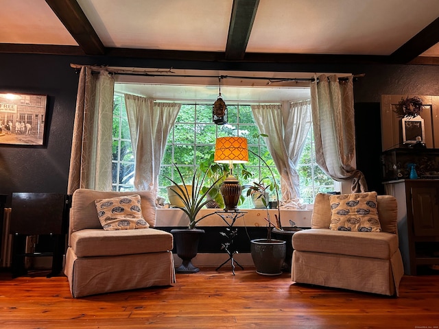 living area with beamed ceiling and hardwood / wood-style flooring