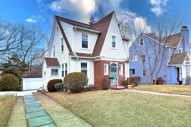 view of front of house featuring a garage, an outbuilding, and a front lawn