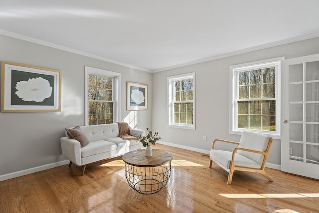 living area with light hardwood / wood-style floors and crown molding