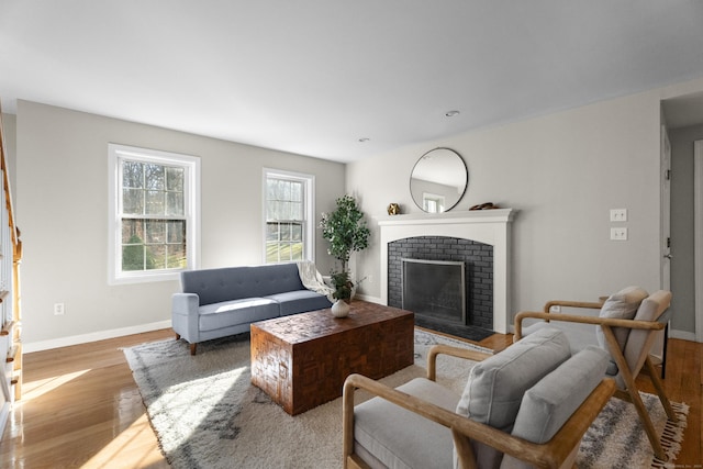 living room with hardwood / wood-style floors and a brick fireplace