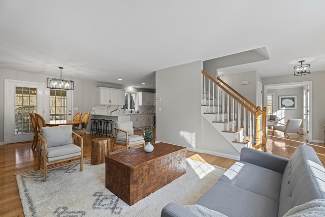 living room featuring light wood-type flooring and a notable chandelier