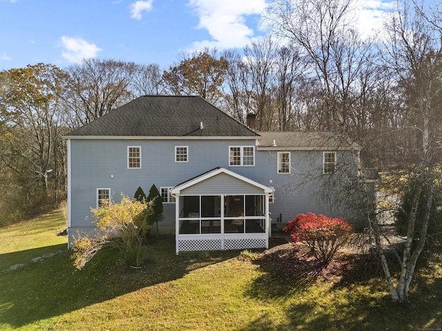 rear view of house with a sunroom and a yard