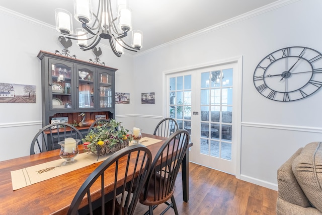 dining space featuring french doors, dark hardwood / wood-style floors, crown molding, and a notable chandelier