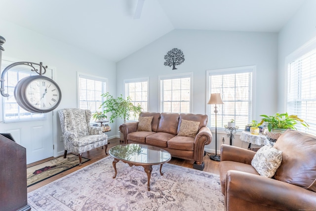 living room with a wealth of natural light, hardwood / wood-style floors, and vaulted ceiling