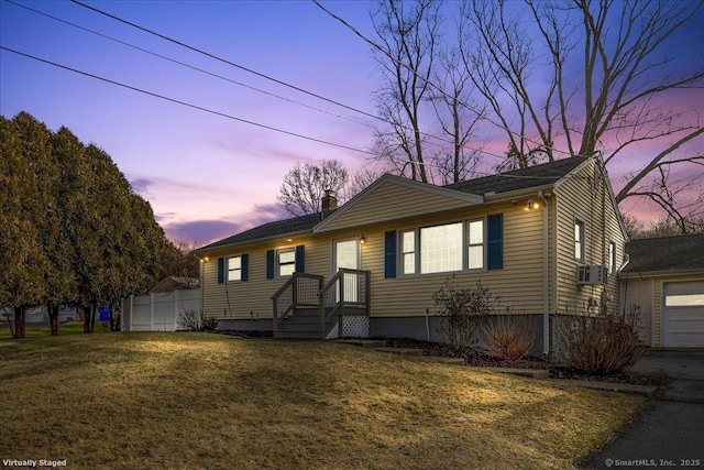 view of front of home with a garage and a lawn