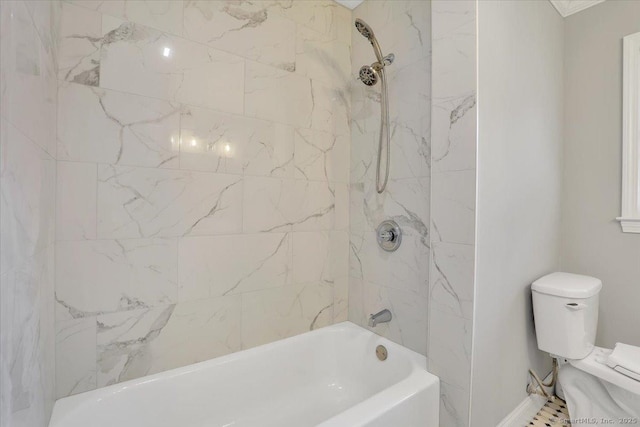 bathroom featuring tiled shower / bath combo and toilet