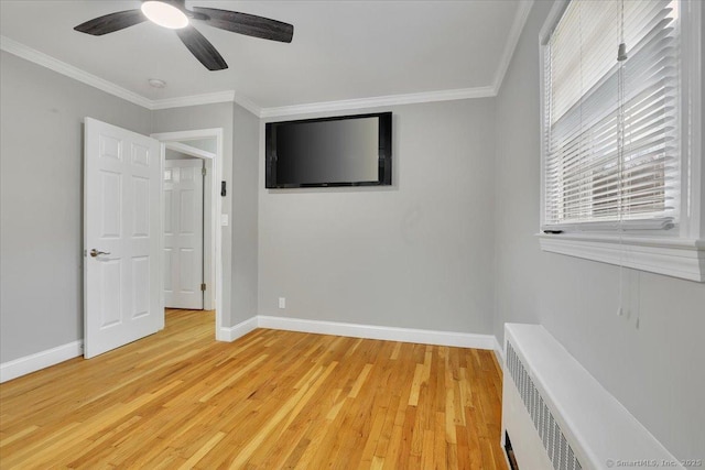 unfurnished bedroom with hardwood / wood-style floors, radiator heating unit, ceiling fan, and crown molding