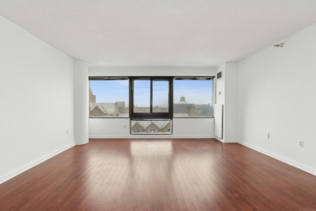 unfurnished room featuring wood-type flooring, a textured ceiling, and a wealth of natural light