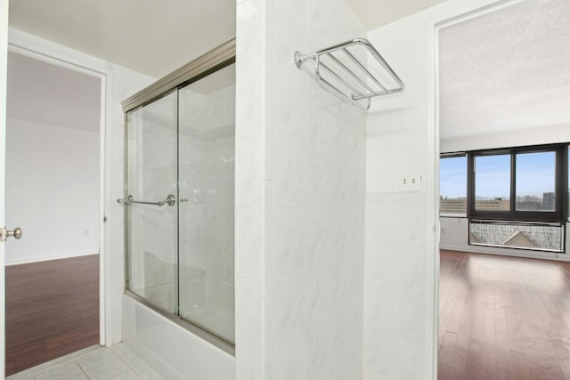 bathroom with tile patterned flooring and combined bath / shower with glass door