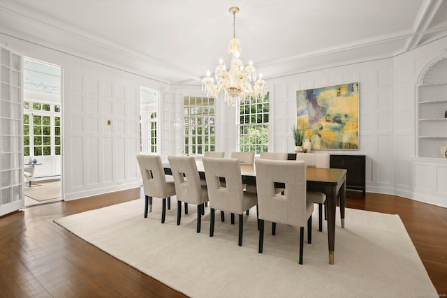 dining space with wood-type flooring, an inviting chandelier, and ornamental molding