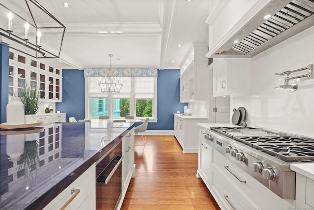 kitchen featuring an inviting chandelier, white cabinets, pendant lighting, and custom exhaust hood