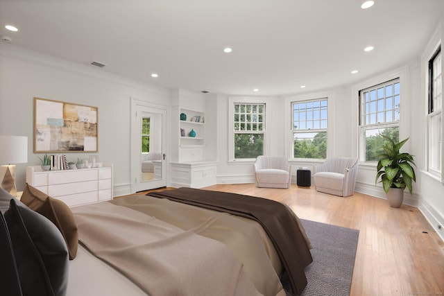 bedroom with crown molding and light wood-type flooring