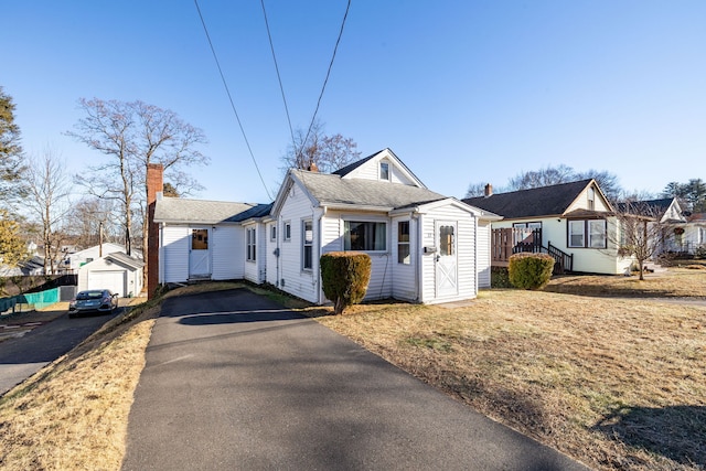 view of side of home featuring a garage and an outbuilding