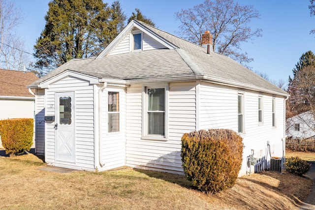 exterior space featuring central AC unit and a yard