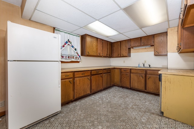 kitchen with a paneled ceiling, sink, and white refrigerator