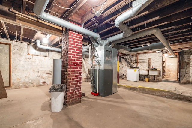 basement featuring sink, washer / clothes dryer, and heating unit