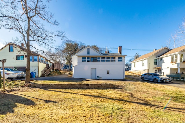 rear view of house featuring a lawn