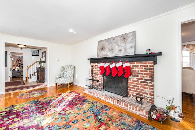 living room featuring wood-type flooring, a fireplace, and ornamental molding