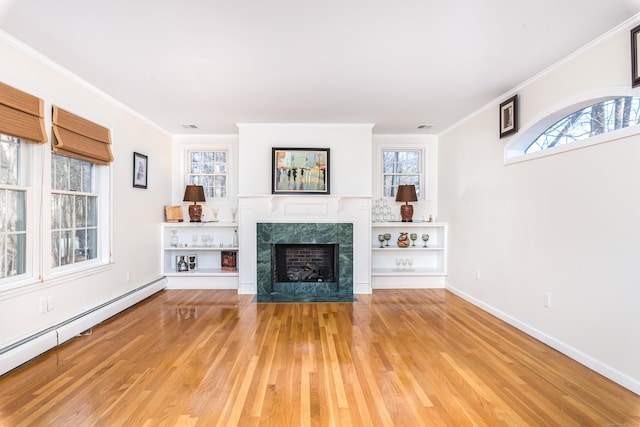 unfurnished living room featuring a baseboard radiator, plenty of natural light, wood-type flooring, a tiled fireplace, and ornamental molding