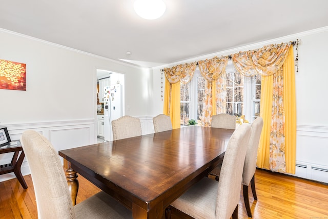 dining room with wood-type flooring and ornamental molding