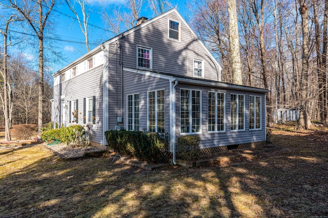 view of side of property featuring a yard and a sunroom