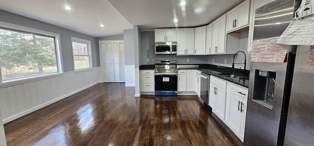 kitchen featuring appliances with stainless steel finishes, sink, dark hardwood / wood-style flooring, and white cabinetry