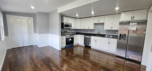 kitchen featuring stainless steel appliances, white cabinetry, and sink