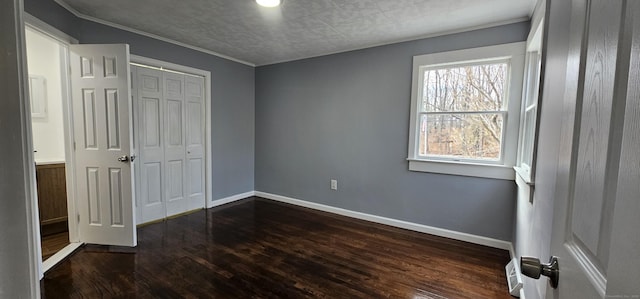 unfurnished bedroom with dark wood-type flooring and a closet