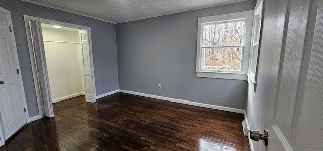 unfurnished bedroom with dark hardwood / wood-style flooring and a closet