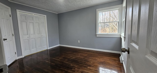 bedroom with dark hardwood / wood-style flooring and a closet