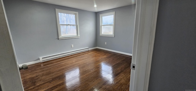 spare room with dark wood-type flooring and a baseboard radiator