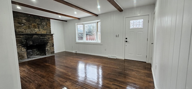 unfurnished living room with a fireplace, dark hardwood / wood-style flooring, beam ceiling, and wood walls