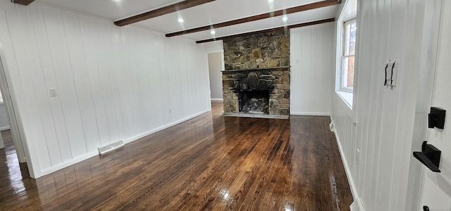 unfurnished living room featuring beam ceiling, a fireplace, and dark hardwood / wood-style flooring