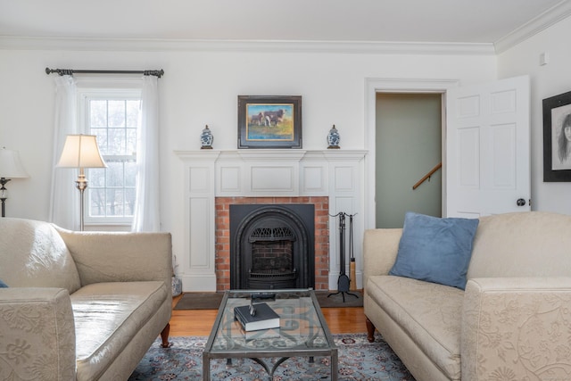 living room featuring hardwood / wood-style flooring, a wood stove, and ornamental molding