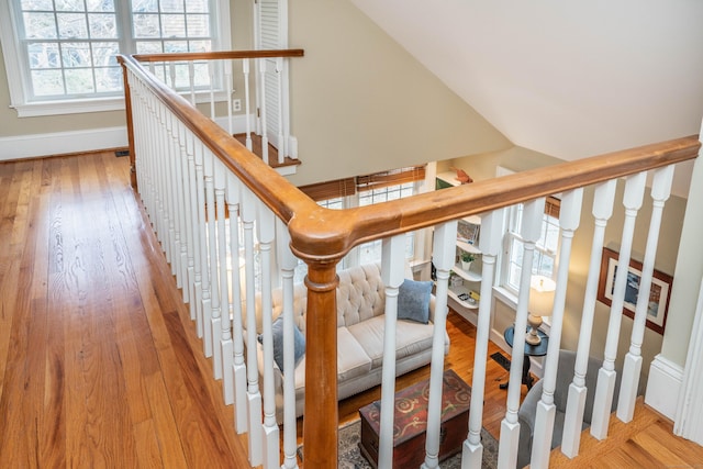 stairway with hardwood / wood-style floors and vaulted ceiling