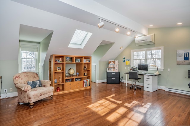 office space featuring vaulted ceiling with skylight, a wall unit AC, wood-type flooring, and a wealth of natural light