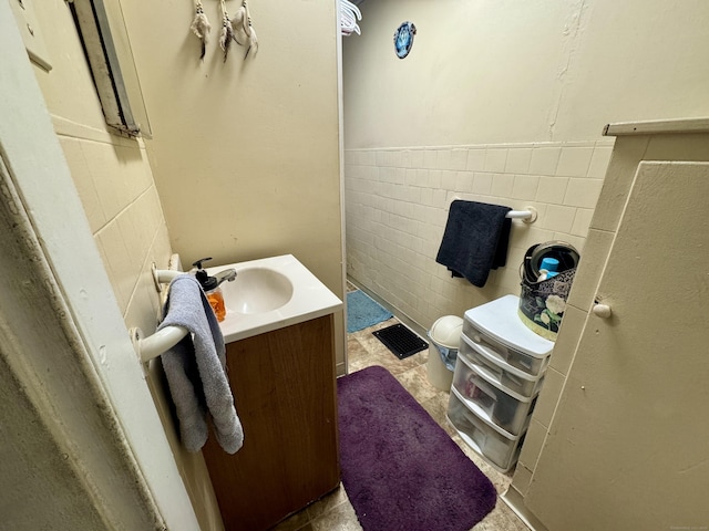 bathroom featuring vanity and tile walls