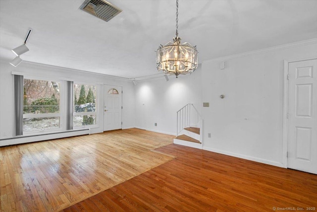 interior space with wood-type flooring, crown molding, baseboard heating, and an inviting chandelier