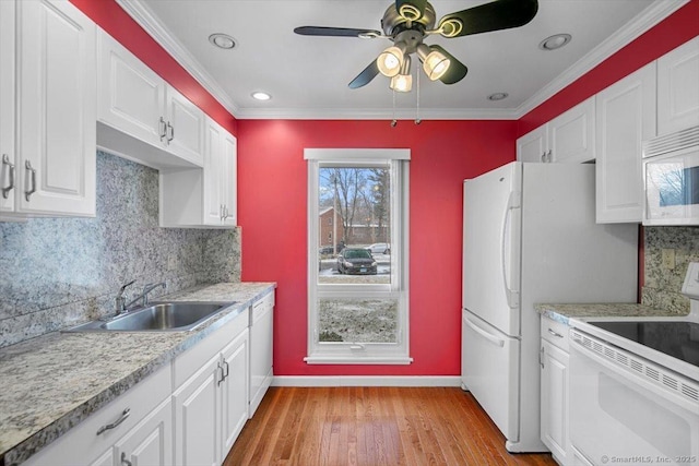 kitchen with tasteful backsplash, white appliances, sink, light hardwood / wood-style floors, and white cabinetry