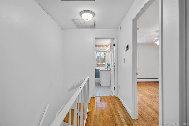 hallway with baseboard heating and light wood-type flooring