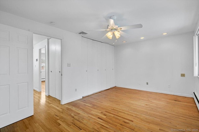 spare room featuring ceiling fan, light hardwood / wood-style flooring, and a baseboard heating unit