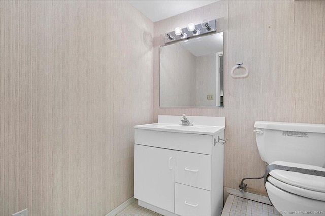 bathroom with tile patterned flooring, vanity, and toilet