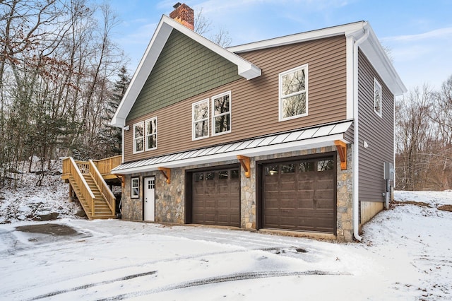 view of snow covered exterior with a garage