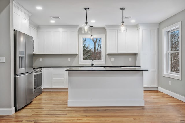 kitchen featuring light hardwood / wood-style floors, stove, stainless steel refrigerator with ice dispenser, white cabinetry, and hanging light fixtures