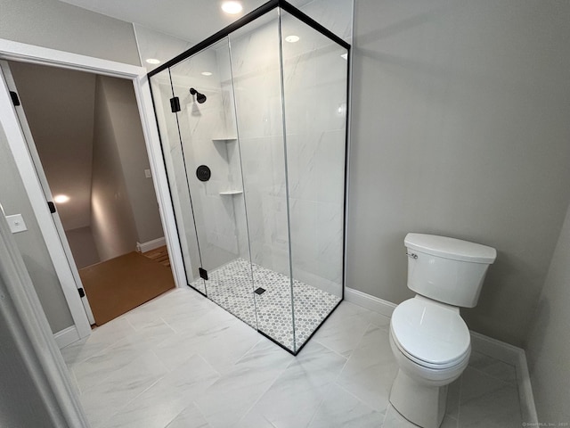 bathroom featuring toilet and a shower with shower door