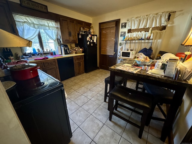 kitchen with light tile patterned floors and black appliances