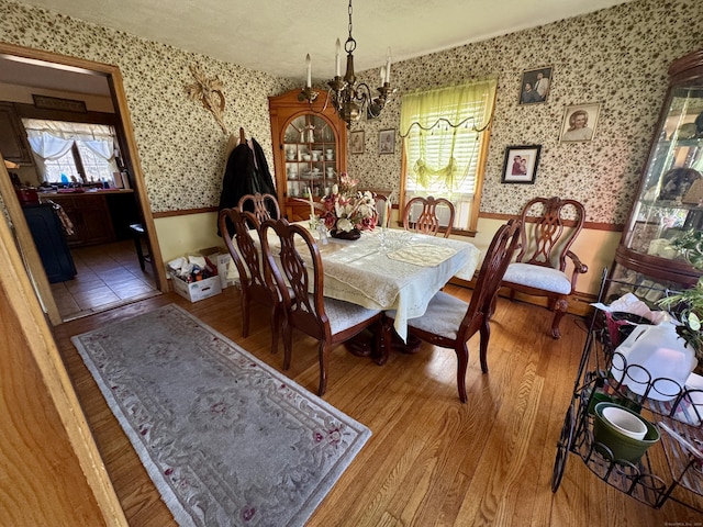 dining area featuring wood-type flooring, an inviting chandelier, and plenty of natural light