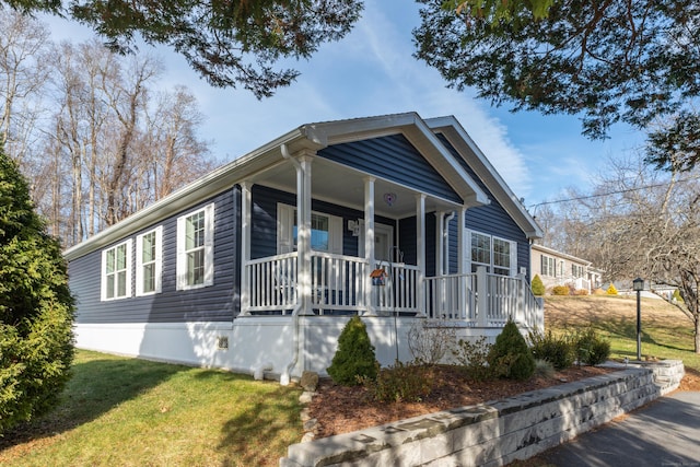 bungalow with covered porch and a front lawn