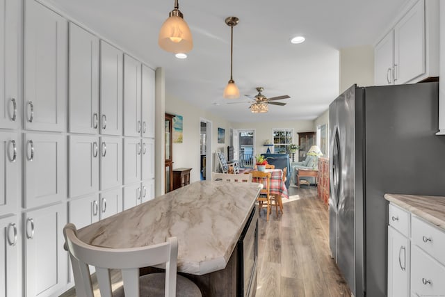 dining room with ceiling fan and light wood-type flooring