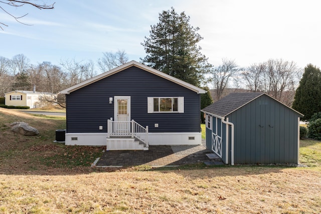 view of front of property featuring a front yard and a shed